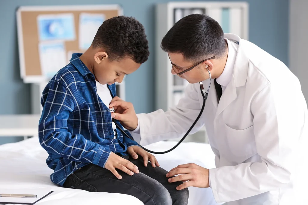 Pediatrician examining boy in clinic