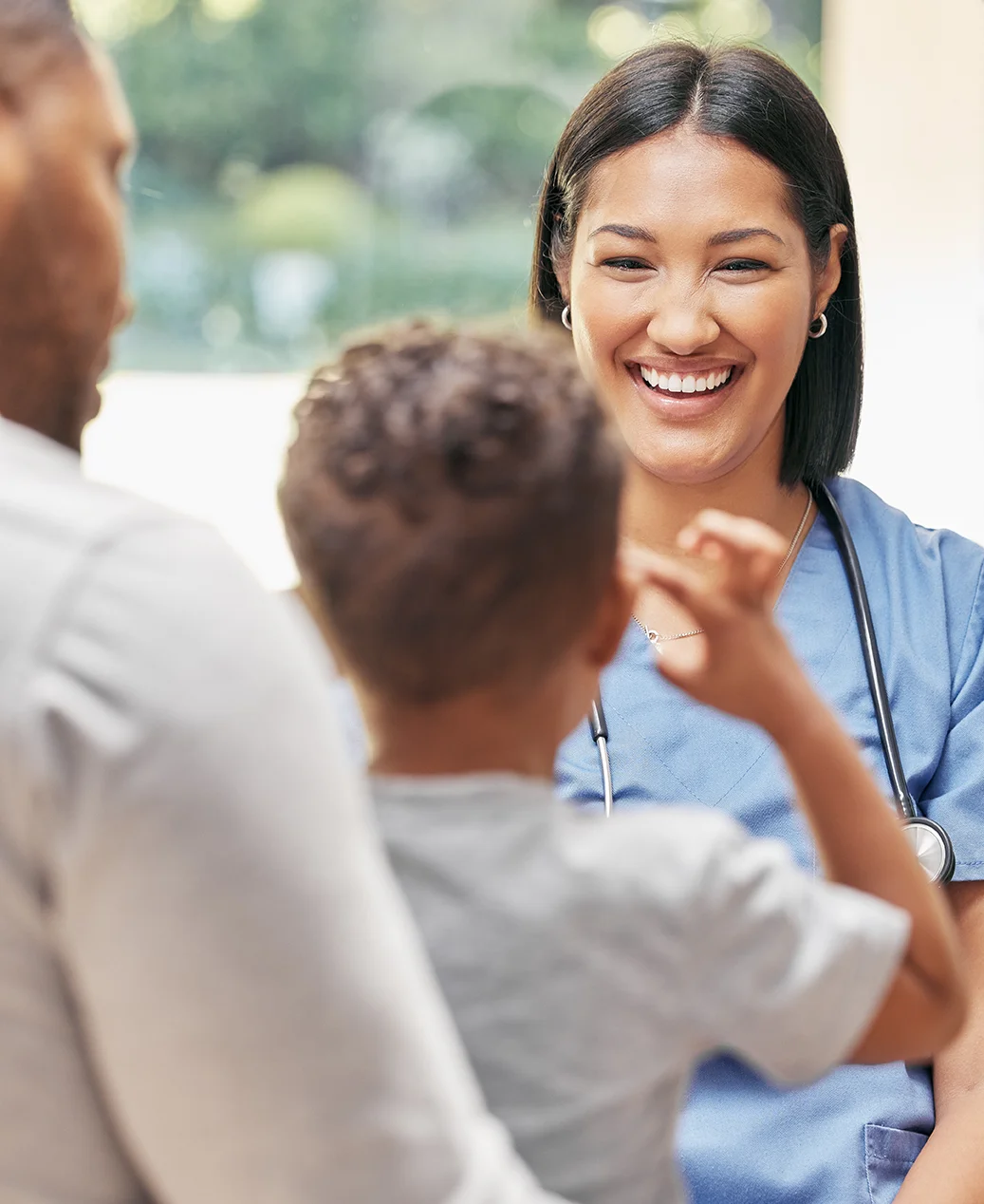Father, child and nurse for health care in a hospital while happy and talking at consultation.