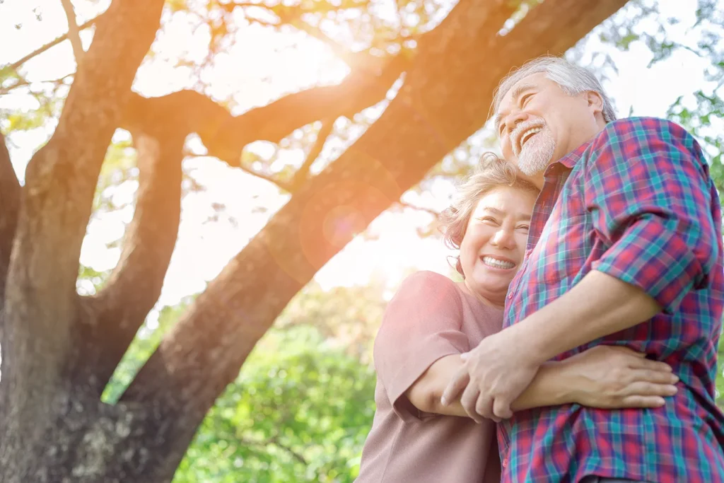 Portrait happiness older couple. Charming grandfather and grandmother is embracing each other with love and smiley faces in a park.