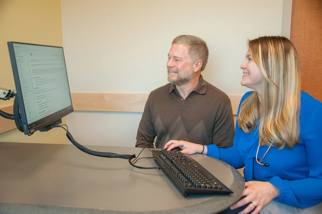 A provider at CVCH sits with a patient at a computer